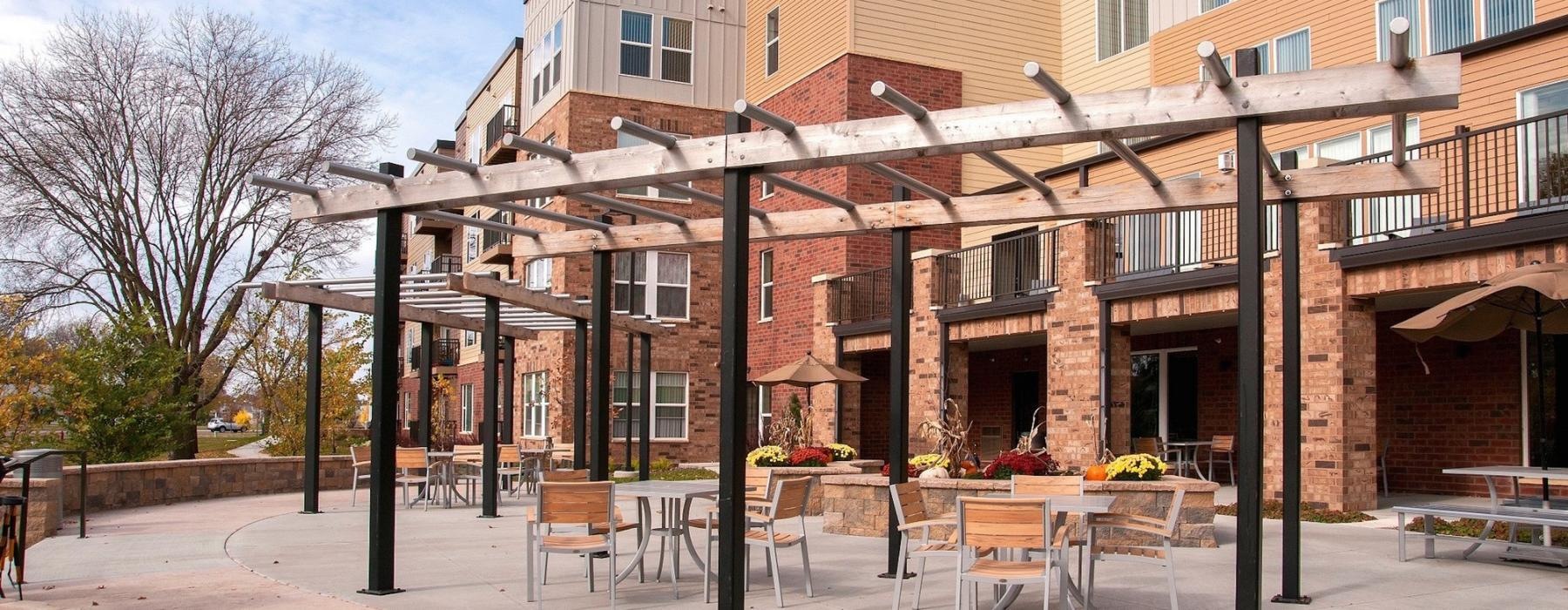 a brick building with tables and chairs outside